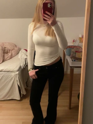 Svarta bootcut jeans - Snygga svarta bootcut jeans och låg midja. Jeansen har en tidlös look och passar perfekt till en enkel topp eller hoodie. Materialet är jeans och färgen är helt svart för en clean vibe.