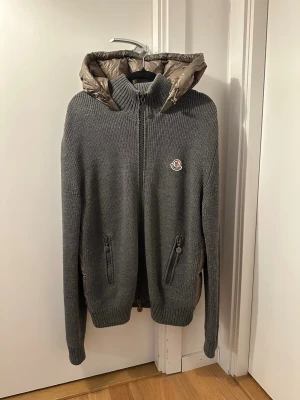 Moncler Cardigan - En av de mest eftertraktade och snyggaste Moncler cardigan på marknaden!| Självfallet äkta, har kvitto och moncler autentication på den!| I princip nyskick, inga defekter alls och storlek L, men passar lätt M med | Väldigt sought after, finns inte alls många på marknaden då det är en äldre modell som ej tillverkas längre!| Noppret ni ser kan man lätt ta bort!| Skriv gärna vid funderingar!⭐️