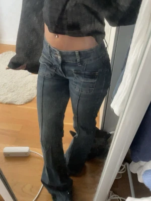 Mellanblå bootcut jeans med låg midja - Snygga mellanblå bootcut jeans med låg midja och klassiska fickor fram och bak. Jeansen har en lätt tvättad look och vida ben nertill. De är normala i storleken och använda ett fåtal gånger.