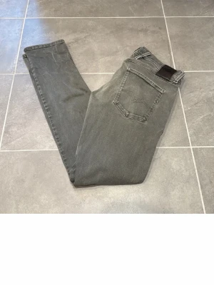 Gråa slim fit jeans från Nudie - Säljer ett par gråa replay anbass storlek 31/34 små i storlek 