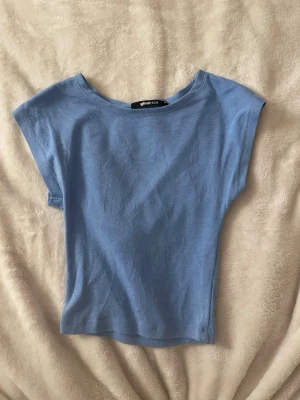 Ljusblå topp från Gina Tricot - En enkel ljusblå topp från Gina Tricot. Den är lite nopprig men har ett jätte skönt matrial som är extremt bekvämt men det kan vara bra att nämna att den är lite kort i modellen.