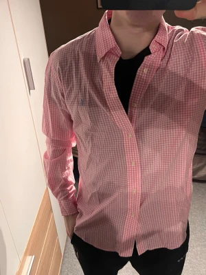 Rosa rutig skjorta från Ralph Lauren - Säljer denna skjorta från Ralph Lauren, bra skick o bra pris! 199! Hör av vid frågor. Den är storlek M. Modellen 181, 77kg