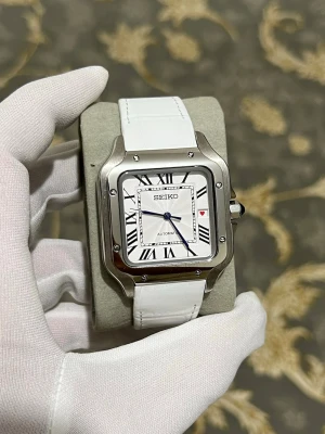 Seiko mode vit Santos  - Stilren fyrkantig klocka från Seiko med vit urtavla, svarta romerska siffror och blå visare. Boetten är i silverfärgad stainless steel och armbandet är vitt. Automatisk rörelse synlig på baksidan. Perfekt för dig som gillar klassisk design.