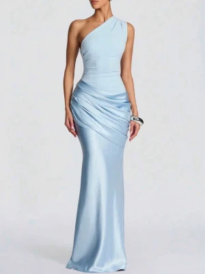 Ljusblå oneshoulder långklänning - Elegant ljusblå långklänning i glansigt material med oneshoulder-design och draperade detaljer över höften. Klänningen har en figurnära passform och ger en sofistikerad look, perfekt för speciella tillfällen.