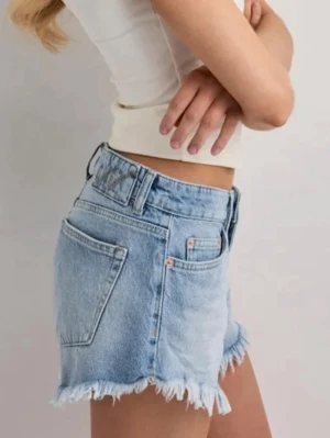 Jeans shorts Nelly.com - Säljer två par jeans shorts från Nelly.com, Fringe jeans shorts. I vit och blå färg. Storlek 34. Nya med etikett! Aldrig använda 