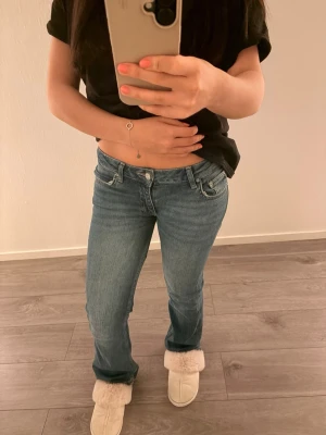 Blå utsvängda jeans med låg midja - Från ginas barn i storlek 158 och dem är nersydda men inget som synns 