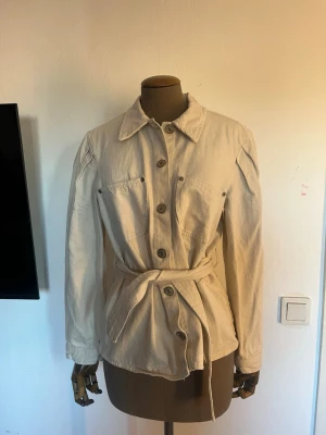 Beige jacka med knytskärp - Storlek M, men är ganska liten i storleken så passar någon bättre som är i storlek Small. 