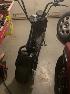 Fatbike - Säljer en svart Fatbike med riktigt breda däck och högt styre men det går att ändra höjden. Scootern har en robust ram i metall, en stor rund strålkastare fram och en bekväm sits. Styret har både fram och bak broms och en tuta. De ända skadorna som fatbiken har syns i bilderna, jag köper ny skärm vid köp av fatbiken som ni får med när ni köper den. Den har räckvidd 60km och en lagom fart. Perfekt för dig som vill cruisa runt med stil och sticka ut på vägarna. Den köptes för 14 000 och är använd.