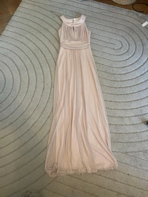 Balklänning❤️ - Elegant ljusrosa långklänning med glittrande tyg och bred krage. Klänningen är ärmlös och har ett vackert fall samt markerad midja. Perfekt för speciella tillfällen där du vill känna dig extra fin.