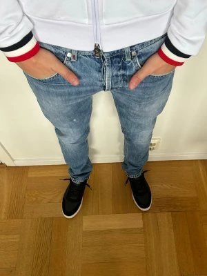 Dondup George jeans - Trendiga Dondup jeans i ljusblå med diskreta slitningar och stilren look. Jeansen har en snygg passform i George modellen och passar både till vardag och mer uppklädda outfits. Viss tidigare defekt (Se sista bild) som har fixats därav det fina priset! Skriv gärna vid funderingar! 