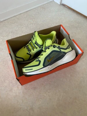 Nike Gore-Tex sneakers - Nike sneakers i neon-gult med svarta och grå detaljer. Skorna har Gore-Tex-material som gör dem vattentäta och tåliga. Snygga snören i svartvitt mönster och en robust sula för extra komfort. Perfekta för dig som vill sticka ut och hålla dig torr.