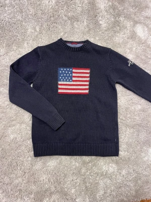 Mörkblå stickad GANT tröja med USA-flagga - Säljer en mörkblå stickad tröja från GANT. Står storlek M men jag skulle säga att den sitter mer som S kanske till och med mot XS-hållet. 