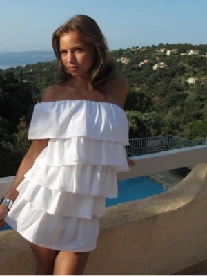 Anielle Vit volangklänning offshoulder - Supersöt vit kortklänning med flera lager volanger och offshoulder-design. Klänningen har en luftig och somrig känsla, perfekt för varma dagar. Tillverkad i ett lätt tyg som ger en flowy siluett och en trendig look. En klänning från Anielle som kostar 1400. Aldrig använt då den var tänkt till student men hittade en annan jag föredrar. Prislapp är fortfarande på. De är en M i standard passform. Perfekt studentklänning