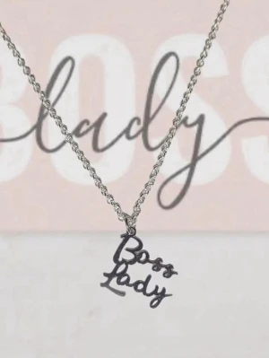 Silvrigt halsband Boss Lady - Snyggt halsband i silverfärgad metall med ett hängsmycke där det står 'Boss Lady' i skrivstil. Perfekt accessoar för att visa att du är självsäker och har koll. Kedjan är tunn och smidig, och texten ger en cool statement-look.