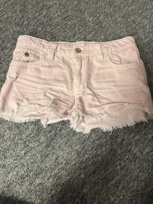 Ljusrosa jeansshorts med fransar - Säljer ett par ljus rosa jeans shorts från Gina Young. 