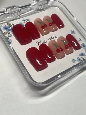  Handgjorda Press-on naglar med körsbärsdesign 3D - Snygga press-on naglar i glansigt rött och nude med körsbärsmotiv. Mix av helröda naglar och naglar med 3D  körsbärsdekor. Mjukt fyrkantig form, perfekt för en trendig look. Kommer i genomskinlig ask.