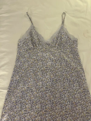 Ljuslila blommigt nattlinne med spets🤍🧖‍♀️ - Sött nattlinne i ljuslila med små blommor i vitt och gult. Tunna axelband och v-ringning med spetskant ger en romantisk känsla. Perfekt för mysiga kvällar hemma. Materialet känns lätt och luftigt.🧖‍♀️🤍