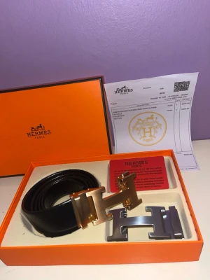 Herm bälte - Exklusivt svart bälte från Herm i äkta skinn med två utbytbara H-spännen i metall.  Snabb leverans stolek 120cm 