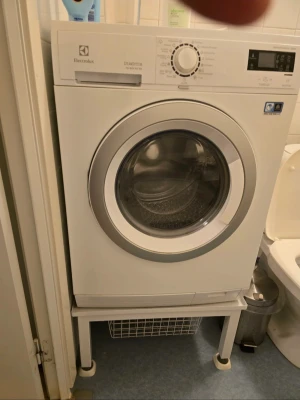 Electrolux vit tvättmaskin - Tvättmaskin från Electrolux i vit färg med rund glaslucka och digital display. Maskinen har flera programval och tydliga reglage på framsidan. Tillverkad i metall och plast, modern och stilren design som passar i de flesta badrum.