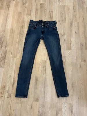Mörkblå Replay jeans - Snygga mörkblå slim fit jeans från Replay i modellen anbass med klassisk femficksdesign och kontrastsömmar. Jeansen har normal midja och raka ben, tillverkade i stretchigt denimtyg för extra komfort. Perfekta för en avslappnad och trendig look. Pris ej hugget i sten och hör av dig vid frågor