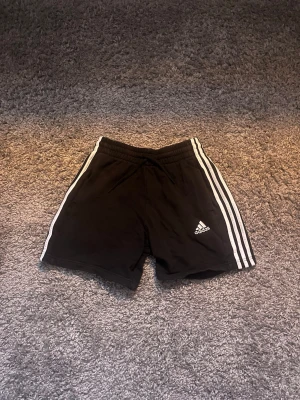 Svarta Adidas shorts med vita ränder - Klassiska svarta shorts från Adidas i storlek S och säljs för 100kr!
