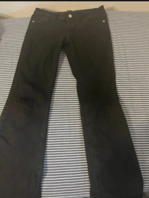 Svarta bootcut jeans från Only - Säljer de populära bootcut jeansen från only!! Dem är belive me LÅGMIDJADE. Jeansen har en lätt utsvängd passform nedtill och är tillverkade i ett mjukt denimtyg som sitter snyggt på benen. Dom har även en slits som ja sytt ihop, då de går ju självklart att spretta upp om det önskas! Jeansen går inte att få tag i längre. Storleken är 30/32 men passar mig som brukar bära w26-27/28. Sitter väldig bra i längden på mig som är 163. Även med skor! 