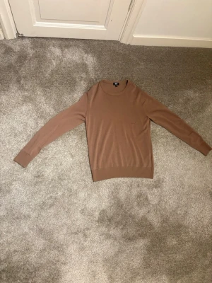 Beige stickad tröja från Uniqlo - Säljer en stilren beige stickad merinoull  tröja från Uniqlo i storlek XS. 100% MERINO