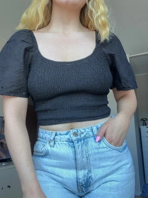 Svart croppad topp med puffärm från Kmart, storlek 10/M - Svart croppad topp med puffiga kortärmar och smockad kropp. Aldrig använd. Köpt på Kmart i Australien. Storleken är 10/M, men passar bra på mig som normalt har S i toppar.