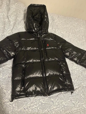Polo Ralph Lauren jacka svart, oanvänd. - Säljer en svart jacka från Polo Ralph Lauren. Jackan har huva med dragkedja framtill och den är helt ny och aldrig använd. 