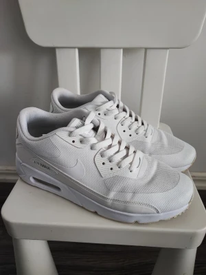 Nike Air Max vita sneakers - Säljer ett par helvita Nike Air Max sneakers med klassisk siluett. Skorna har mesh- och syntetmaterial, soprena linjer och synlig Air-enhet i sulan. Perfekta för dig som gillar stilrena och sportiga sneakers med ikonisk design.