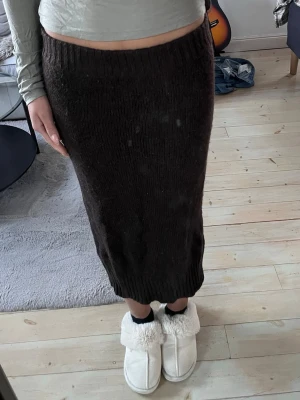 Stickad kjol från Gina tricot - Brun stickad kjol från Gina tricot med en liten slits på vänster sida! Passar M-L