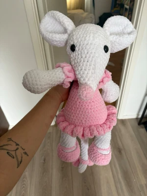 Handvirkad dansmus i rosa klänning - Supergullig handvirkad dansmus i vitt och ljusrosa velvet garn. Musen har stora öron, svarta ögon och bär en rosa klänning med volang samt matchande skor och rosett. Är cirka 45 centimeter stor (ej medräknat svans). Perfekt som dekoration eller gosedjur för människor i alla åldrar! 