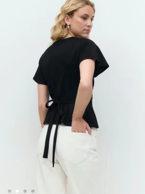 Svart oanvänd blus med knytning i ryggen  - Trendig svart blus som inte finns kvar med djup v-ringning och korta, vida ärmar. Toppen har knytband i midjan som ger en snygg siluett. Perfekt att styla med jeans eller kjol för en cool look. I st M men passar S också och denna är helt oanvänd. Nypris 299kr.💕 Jag har inte kvar förpackningen men kanske har kvitto kvar 