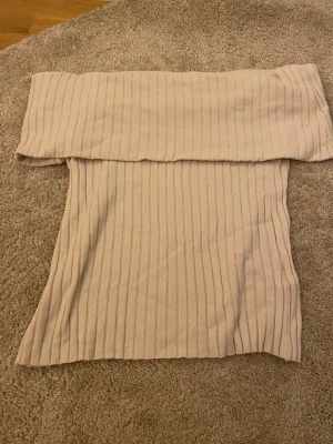Beige off shoulder ribbad topp - Beige ribbad tröja med off shoulder-design från Stockh LM. Mjuk och stretchig kvalitet som sitter snyggt på kroppen. Storlek M men passar för folk i storlek S eller också.