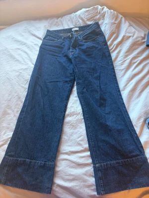 Blå utsvängda jeans från Perfect Jeans - Säljer ett par mörkblå jeans från Perfect Jeans i modell med utsvängda ben. Klassisk femficksdesign och hög midja. Jeansen har en snygg tvätt och är tillverkade i ett kraftigt denimtyg som ger en tidlös look.