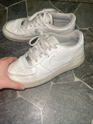 Vita Nike Air Force 1 sneakers - Klassiska vita Nike Air Force 1 sneakers i storlek 39. Slitna vid hälarna men inget som syns när skorna är på. 