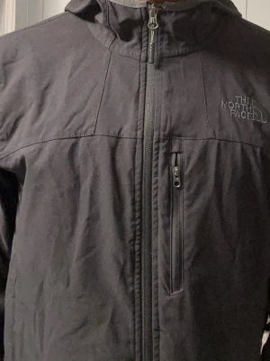 Svart vindjacka från The North Face - Svart vindjacka med luva från North Face. Bra för sport och träning i höstväder.