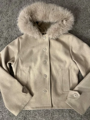 Beige kappa med päls från Gina Tricot - Säljer min jätte snygga beiga kappa från Gina Tricot i storlek S, som tyvärr inte kommer till användning. 