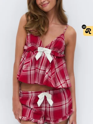 Röd rutig pyjamas med rosetter - Söt pyjamas i rödvitt rutigt mönster med volangkant och vita rosetter framtill. Setet består av ett linne med smala axelband och matchande shorts. Perfekt för mysiga hemmakvällar och har en ungdomlig, lekfull stil.