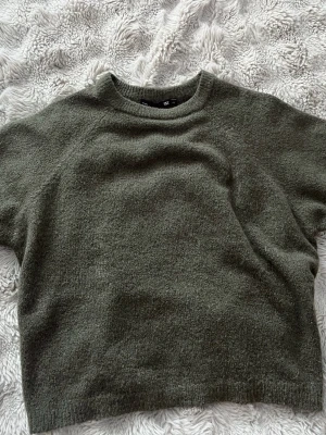 Olivgrön stickad tröja  - Stickad t-shirt i jättefin mörkgrön färg. Helt ny och aldrig använd. Prislappen finns kvar men är avtagd. Storlek XS🤍🌿
