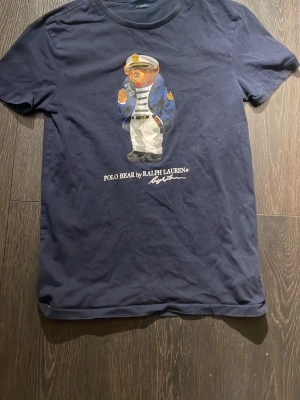 Mörkblå slim fit t-shirt Polo Ralph Lauren - Snygg mörkblå t-shirt från Polo Ralph Lauren i slim fit-modell. Klassisk rund halsringning och diskret design som passar till allt. Tillverkad i mjuk bomull för skön känsla hela dagen.
