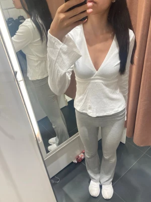 Vit omlottblus med v-ringning - Snygg vit omlottblus från Gina Tricot med djup v-ringning och långa, lätt utsvängda ärmar. Blusen har en lätt strukturerad yta och knytdetalj i midjan som ger en feminin siluett. Perfekt att styla med jeans eller kjol. Första bilden är från när jag köpte den❤️. Defekten bild fyra är bara en sömn som har gått upp. Så den syns inte så mycket😊nystrykt och färdig att packas! Frifrakt till söndag 26 april