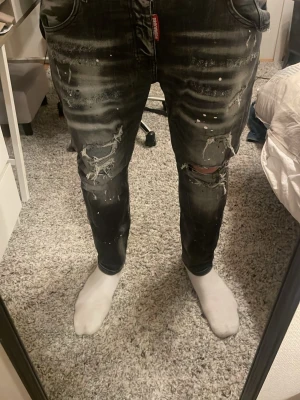 Mörk gråa jeans från Dsquared2 - Säljer ett par mörkgråa jeans från Dsquared2 med slitningar, trasiga detaljer och vita färgstänk. Storlek 54 men väldigt små i storleken skriv vid mer frågor svarar snabbt. Pris kan diskuteras vid snabb affär