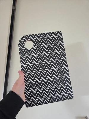 Bricka MellowDesign - Säljer en stor skärbräda/bricka från Mellowdesign. Svartvitt zigzag-mönster och rundat hörn med hål för upphängning. Dyr i inköp!