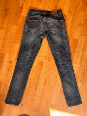 Nudie grim tim med snygga fades  - Säljer ett par blå jeans från Nudie Jeans med klassisk femficksmodell och snygga fades. Jeansen är i storlek w31 l34.