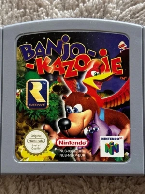 Banjo-Kazooie Nintendo 64 spel - Banjo-Kazooie till Nintendo 64, klassiskt äventyrsspel från Rareware. Grå plastkassett med färgglad etikett som visar spelets karaktärer. Perfekt för retrospelare som vill uppleva ikoniska plattformsspel på originalkonsol.endast kassetten Pal:v