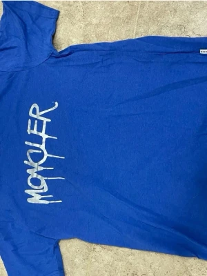 Blå t-shirt från Monomer - Cool blå t-shirt från Monomer med vit tryckt logga på bröstet. Klassisk passform och korta ärmar, perfekt för dig som gillar streetstyle. Materialet känns mjukt och bekvämt, troligen bomull. Snygg att matcha med jeans eller shorts.