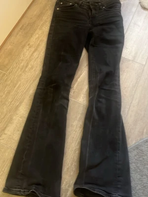 Mörkgråa/svarta bootcut jeans - Säljer ett par svarta bootcut jeans i full lenght xs med låg midja. 