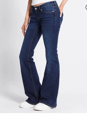 Mörkblå Bootcut jeans  - Slutsålda jeans från Lager 157, snygga bootcut jeans i mörkblå denim, jeansen har låg midja och är tillverkade i ett stretchigt material som ger en bekväm passform. Perfekta för dig som gillar en tidlös och cool look. Endast använd ett fåtal gånger så nästan nyskick. Orginalpris 300kr.