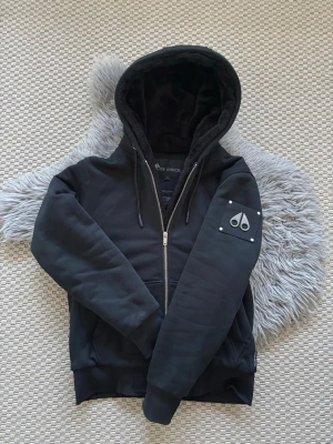 Moose Knuckles Hoodie/Jacka (S/M) - Moose Knuckles vår/höst jacka, storlek S men passar även M, pyttelitet hål i armsluten men inget som syns, förutom det inga konstigheter.